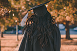 Person in academic gown walking away from camera