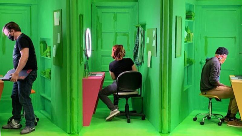 Three actors on green screen set divided into cubicles