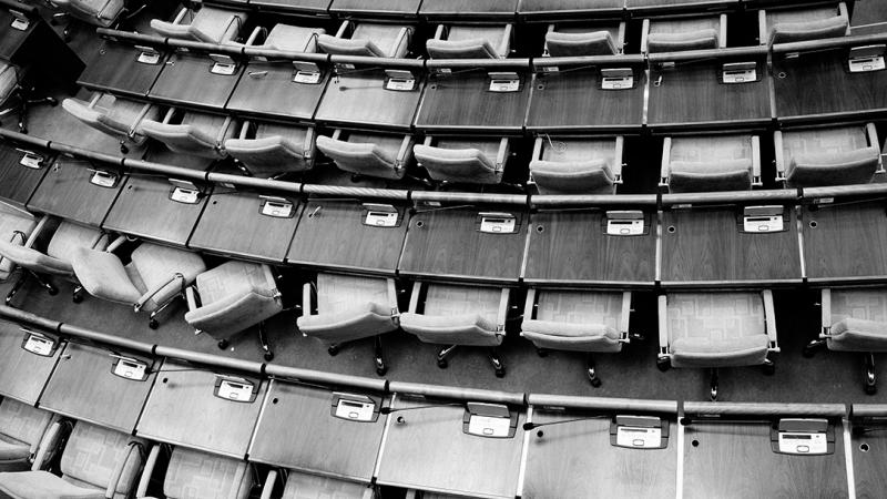Empty chairs and desks are showed in black and white