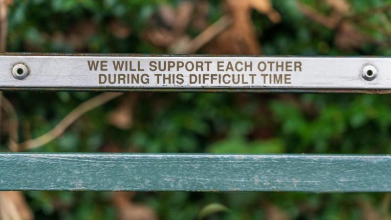 We will support each other, written on a park bench.