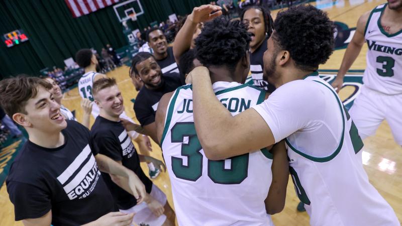 Cleveland State University basketball players embrace in joy. 
