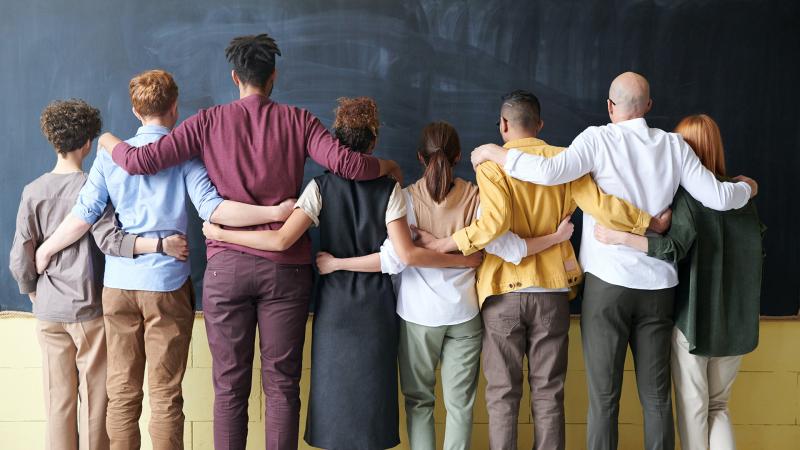 A diverse group of people with their backs to the camera.