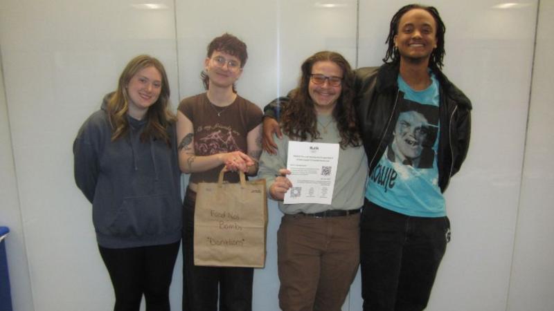 From left, Secretary Olivia Stein, President Audrey Menner, Vice President Henry Clay and Treasurer Jude Ouma stand together during the first meeting of Students for a Just Society on Feb. 26, 2026, in Berkman Hall, Room 319 at Cleveland State University.