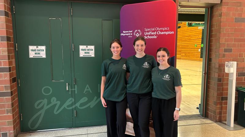 Ashley Browske, center, event organizer, poses alongside fellow occupational therapists Kacie McPeek, right, and Cameron Budzik, left, before welcoming 150 students in for the Special Olympics basketball event on March 27, 2026.