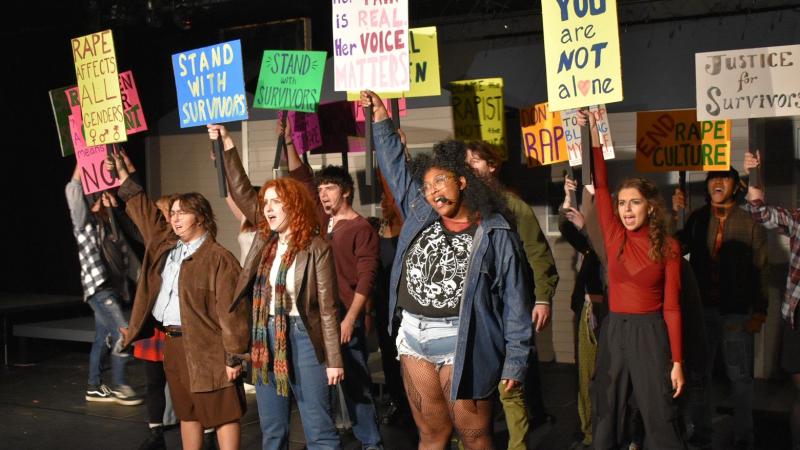 Performers in The Jagged Little Pill hold up protesting signs
