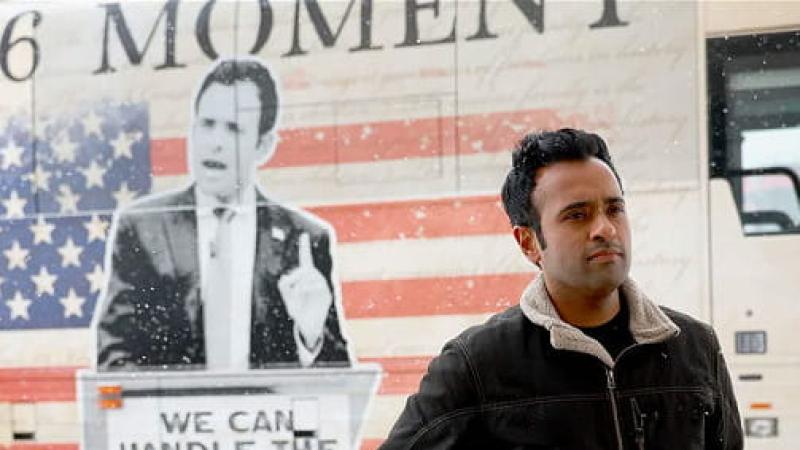 Vivek Ramaswamy standing in front of one of his ads for the 2024 election. 