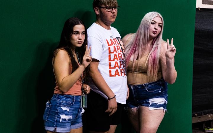 Students posing in front of green screen