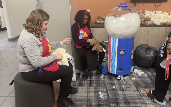 Workers fill Build-A-Bears with stuffing using their whimsical machines.