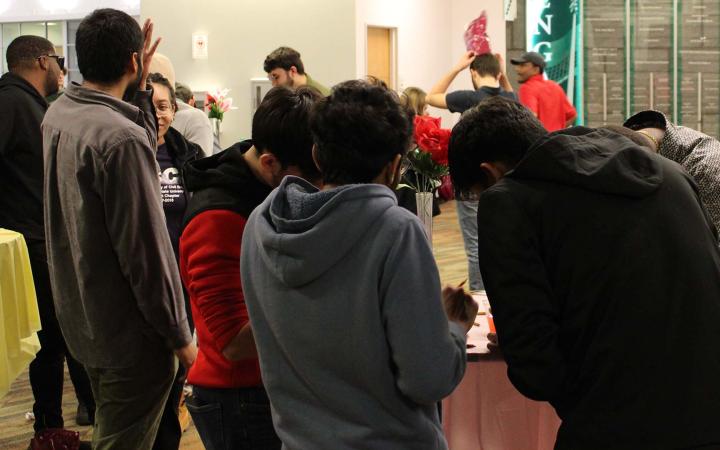 Students gather around a table to fill out their raffle tickets.