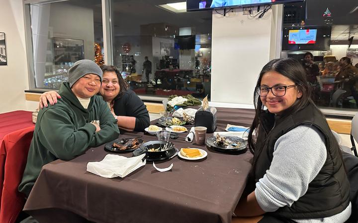 Student Bella Perez and her parents pose for picture after finishing their Vikesgiving meal.