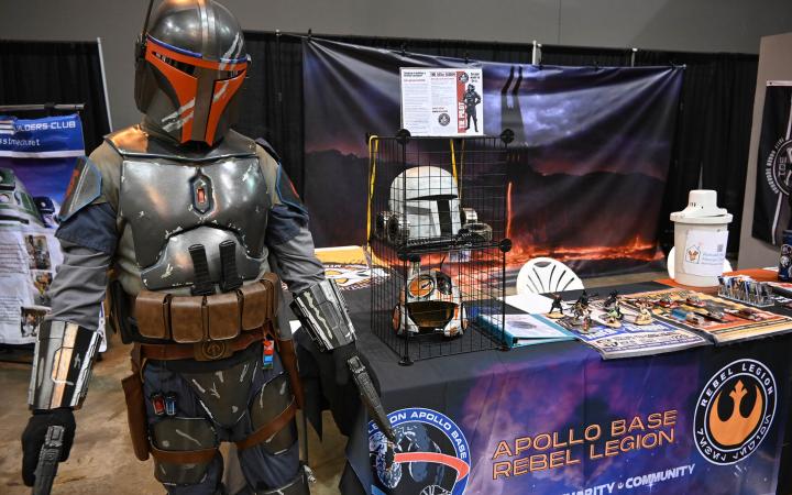 A mandolorin from the Star Wars franchise poses in front of the global charity and community group Apollo Base Rebel Legion stand. (credit: Alex Martinez)