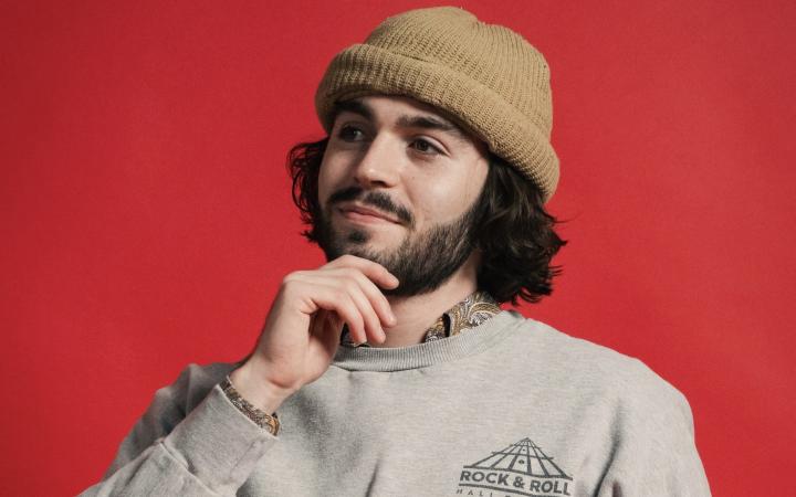 Liam Main in front of a red background