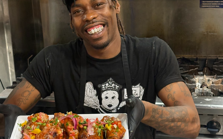 Agave & Rye kitchen manager Andre presenting a plate of the “Thai-ed with Benefits” specialty wings during Wing Week in Cleveland, Aug. 29, 2025.