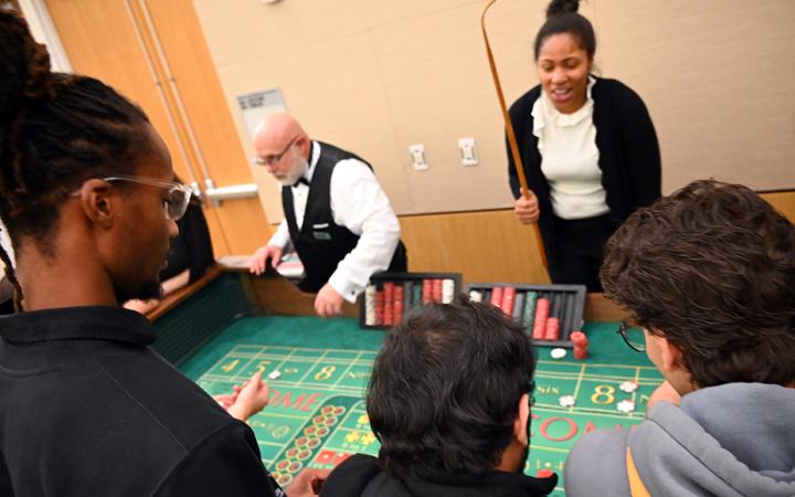 Students play craps, a dice game where players bet on the outcome of the roll of a pair of dice. (credit: Alex Martinez)