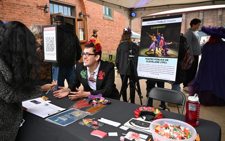 Alejandro Martinez, an employee for the Cleveland Public Theatre, tells attendees what the TPC is about at a table advertising upcoming events, Nov. 1, 2025. (credit: Alex Martinez)