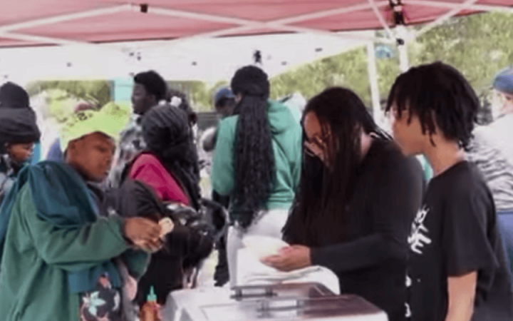 New Era Scholars members handing out clothing, food and hygiene products at the Operation Love event on Sept. 25, 2025. (credit: Melvin Carter)