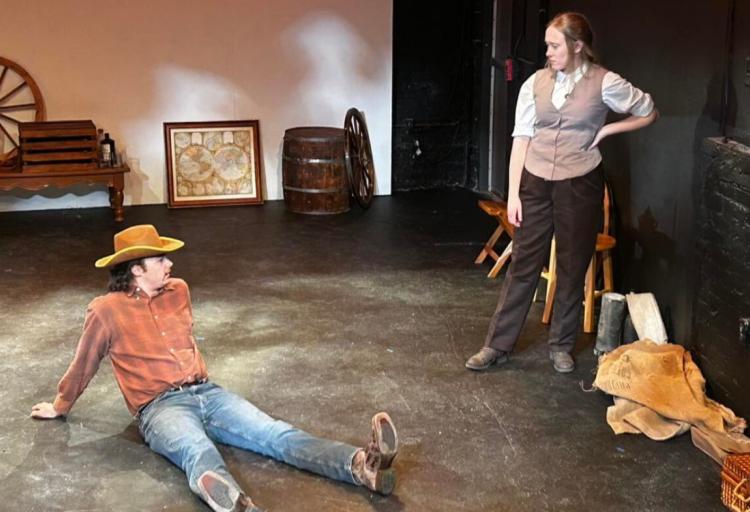 Randall McCain (left, played by Nicholas Hassan) and Cecilia Donne (right, played by Katie Steim) sitting under the Louisiana sun and waiting for their train to arrive.