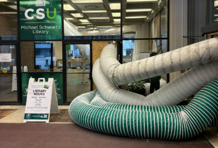 Water being piped out of Rhodes Tower after an incident in spring 2026 forces a partial closure of the building.