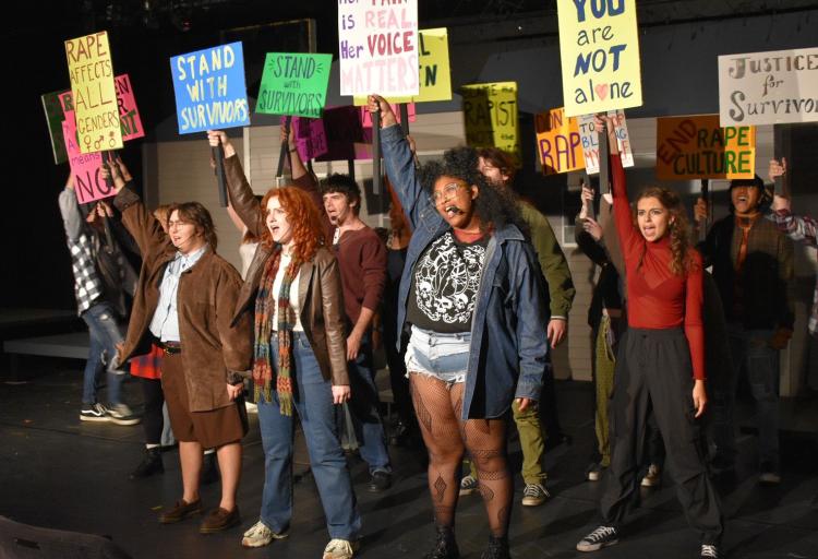 Performers in The Jagged Little Pill hold up protesting signs