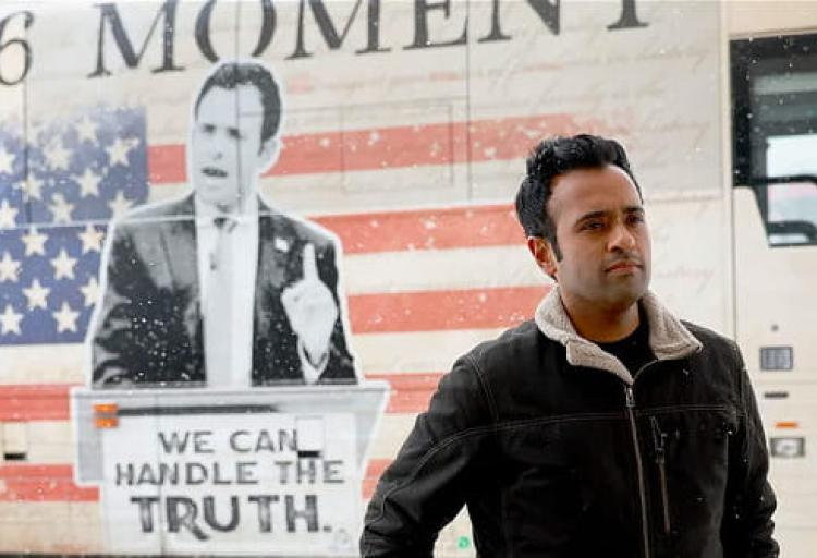 Vivek Ramaswamy, who is running for Ohio governor, standing in front of one of his ads for the 2024 presidential primary campaign.