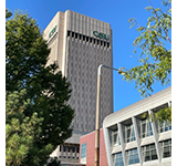 CSU's Rhodes Tower pictured with a bright blue sky and trees surrounding it.