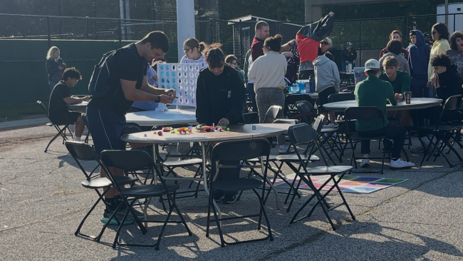 Athletes play board games on the tarmac, Oct. 7, at the Special Olympics. (Credit: Tony Pisaneschi)