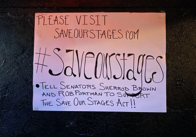 A Save Our Stages sign hangs on the wall of the B-Side Liquor Lounge in the basement of the Grog Shop in Cleveland Heights, Ohio.