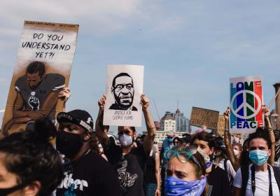 A protester holds an image of Colin Kaepernick (left) ahead of one of George Floyd (center) at a Black Lives Matter march in New York City on June 4, 2020.
