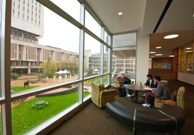In this file photo taken before the coronavirus pandemic emptied campus, students sit in the CSU Student Center. The Michael Schwartz library is visible to the left through the window.
