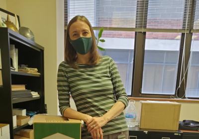 Picture of Jennifer McMillin, director of sustainability leaning on recycling box.