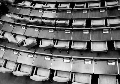 Empty chairs and desks are shown in black and white