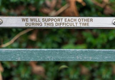 We will support each other, written on a park bench.