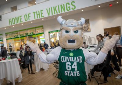 Mascot Magnus poses in front of Giving Day event in Student Center Atrium
