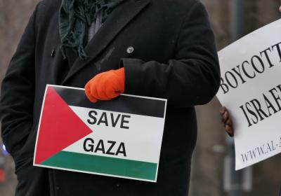 Demonstrators holding signs at a free Palestine rally.