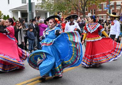 Women wearing folklorico dresses dance in Cleveland's Day of the Dead parade on Nov. 4, 2023.