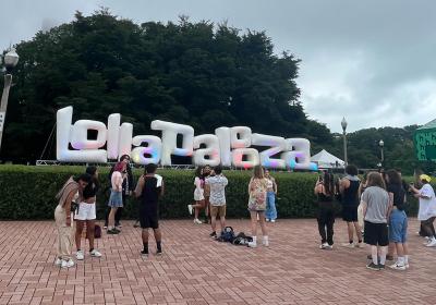 People wait by Lollapalooza sign to take pictures upon entering the festival.