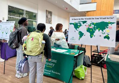 Eliza Tickhill, Education Away alum, center, helps register students at the Education Away Fair on Thursday, Oct. 2, 2025.