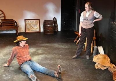 Randall McCain (left, played by Nicholas Hassan) and Cecilia Donne (right, played by Katie Steim) sitting under the Louisiana sun and waiting for their train to arrive. 
