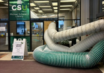 Water being piped out of Rhodes Tower after an incident in spring 2026 forces a partial closure of the building.