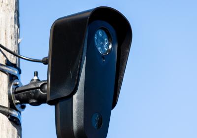A Flock ALPR license plate reader camera fixed to a pole. 