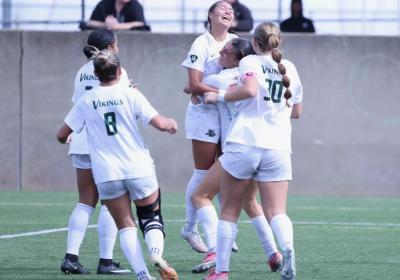 Cleveland State women’s soccer players celebrate with junior True Benshoff after she scored the game-winning goal in the Vikings’ 1-0 victory over Detroit Mercy on Oct. 10.