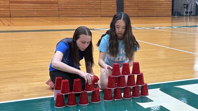 Two sorority sisters stacking cups during Greek Week relay