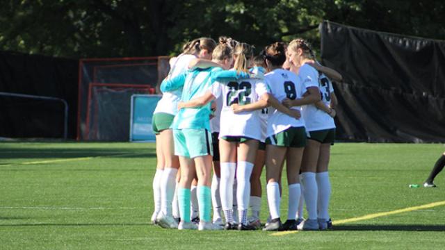 CSU women's socccer players huddle.