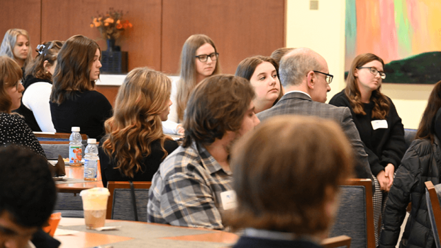 Students and professionals listening to Dr. Beth Thomas open the event