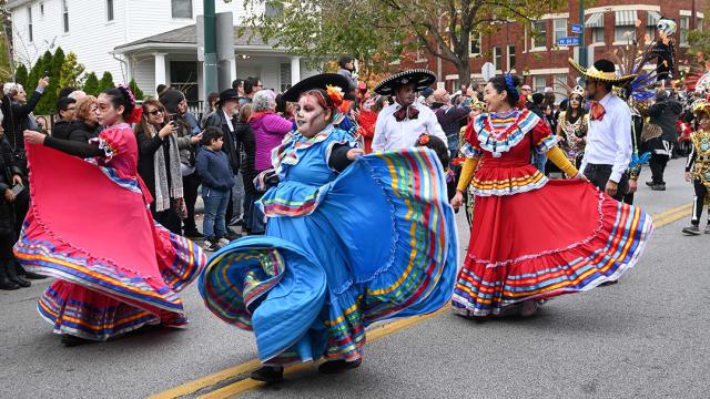 People dressed up in a parade for Cleveland's 19th Dia de los Muertos festival.