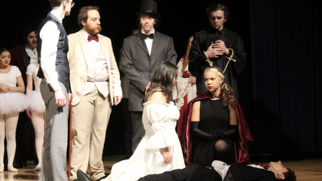 The cast stands over a dead Phantom.